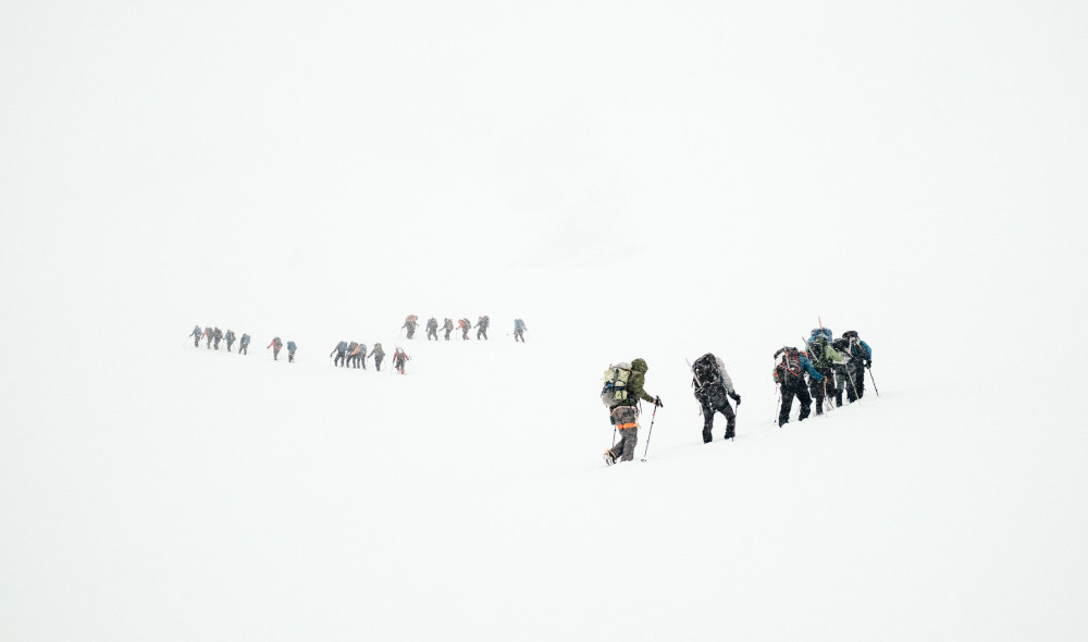 A team of mountaineers climbing a mountain filled with snow